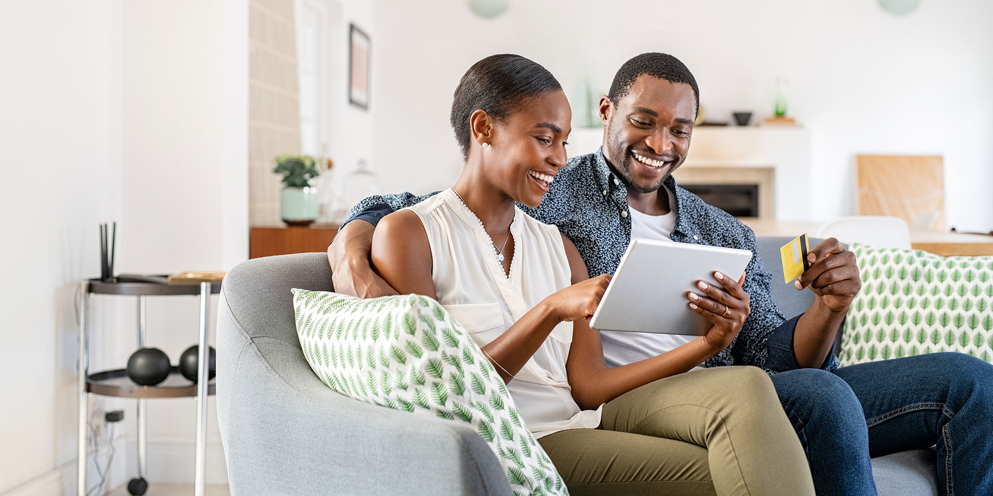 Happy couple on their tablet device applying for an interest-bearing checking account.