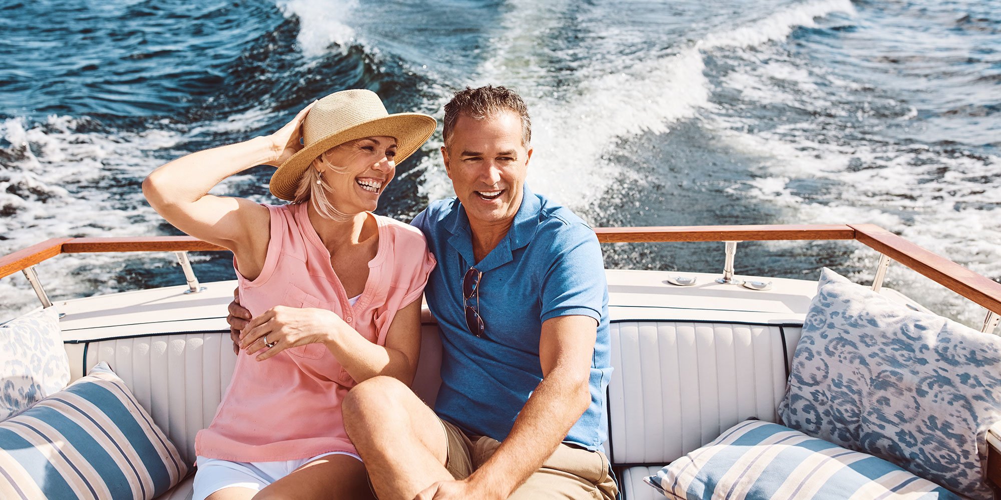 Smiling man and woman, riding on boat. 